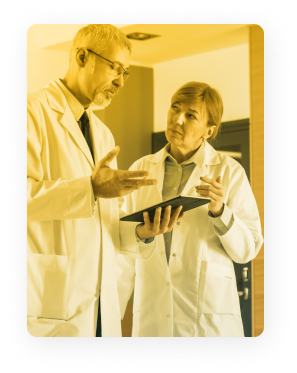 Two doctors discussing their documentation on a laptop. Two doctors discussing their documentation on a laptop.
